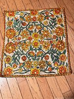 Front view of placemat showing full embroidered floral design and border