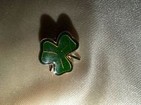 Front view showing green enamel shamrock with gold outline