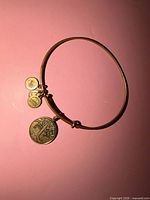 Full view of gold-tone expandable bangle with Tree of Life charm