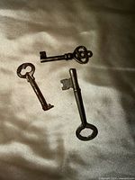 Three skeleton keys on fabric surface