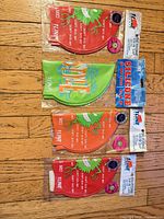 Front view of four packaged swim caps showing colors and designs