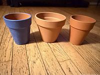 Three terracotta pots side by side showing colors and condition