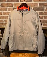 Front view of tan Chaps half-zip jacket on hanger