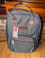 Front view of grey ALLCAMP picnic backpack with tag attached