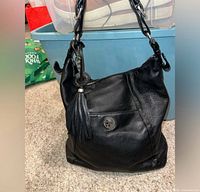 Full view of black leather shoulder bag standing upright