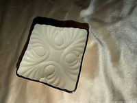 Top view of square Lenox trinket dish showing embossed design and silver rim