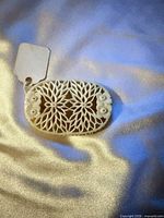 Front view of oval carved floral brooch