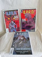 Front covers of all three B.P.R.D. issues in bags