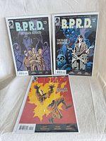 Front covers of issues #1, #2, #5 in bags with boards