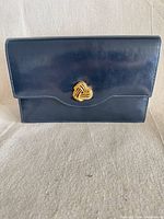 Front view showing navy leather and gold knot clasp