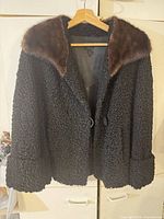 Front view showing black Persian lamb coat with dark brown mink collar and single button