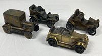 Group of four brass-tone die-cast automobile coin banks