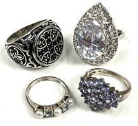 Group shot of four silver tone rings showing designs and relative sizes