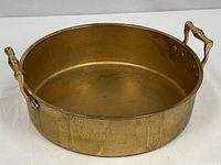 Full view of brass deep sauté pan showing body and both handles