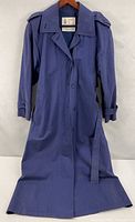 front view of full length blue raincoat showing buttons, collar, epaulets, belt