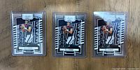Front view of three identical 2023 Panini Absolute CJ Stroud rookie cards in plastic sleeves