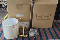 Two boxed sconces, one shade, one brass sconce arm and mounting hardware displayed