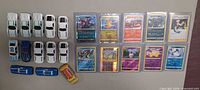 Overview of all die-cast cars and Pokémon cards laid out