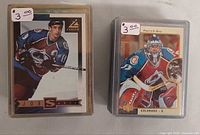 Patrick Roy and Joe Sakic cards in top loaders