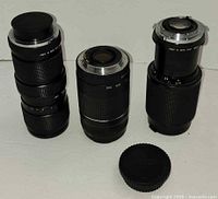 Group shot of three lenses and loose rear cap