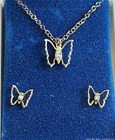 Necklace and earrings displayed on blue velvet insert