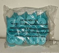 Front view of sealed bag showing light blue curlers and warning text