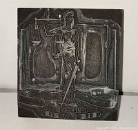 Front view of metal relief Lady Justice image on wooden block