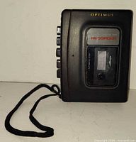 Front view showing Optimus branding, cassette window and wrist strap