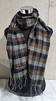 Full view of scarf on mannequin showing plaid pattern and fringe
