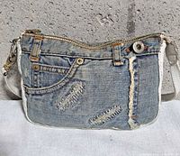 Front view showing distressed denim, pocket, D&G button, zipper