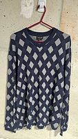 Front view of navy and grey argyle Giorgio Armani sweater on hanger