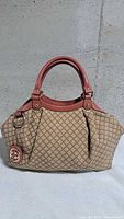 Front view of Gucci diamante canvas Sukey handbag with pink leather trim and GG charm