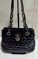 front view showing quilted pattern, clasp and handles