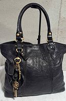 Front view of black Juicy Couture lambskin tote showing handles and charm