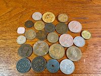 Top view of all 25 coins arranged on wooden surface