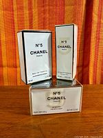 Three sealed Chanel No.5 products: eau de parfum 50 ml, hair mist 40 ml, bath soap 150 g