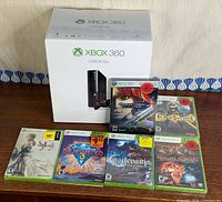 Console box with six sealed Xbox 360 games displayed
