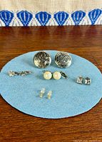 All five earring pairs on blue mat