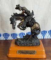 Front view of bronze-tone resin sculpture on wood base