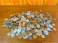 Overall pile of mixed coins on wooden surface