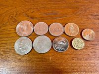All ten coins laid out on wooden surface