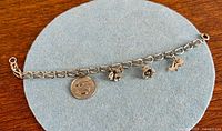 Full view of bracelet with four charms laid flat