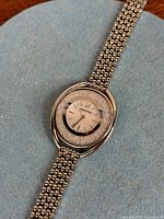 Front view of Swarovski Crystalline Oval watch on blue background