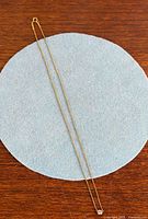 Full length view of necklace on blue felt circle