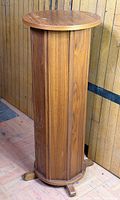 Full view of wooden pedestal showing cylindrical body and base