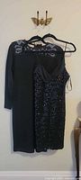 Both dresses hanging: long-sleeve beaded sheath and LoriAnn sequined cocktail