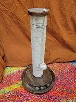 Full view of scratching post showing wood base, sisal post, rope ball
