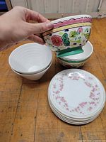 Stacks of two bowl styles and stack of floral rim plates