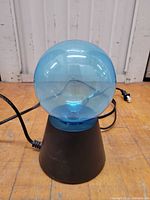 Front view of blue globe plasma lamp showing globe, base, and power cord