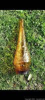 Full view of amber empoli bottle on grass